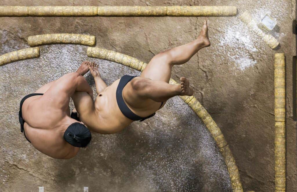 Two sumo wrestlers grappling on the dohyo.