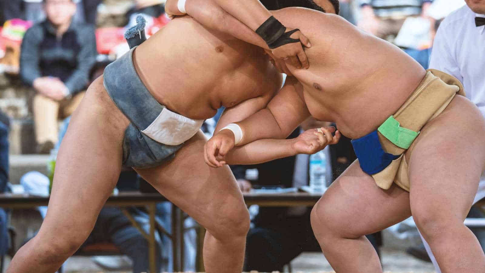 Two sumo wrestlers grappling during a match.