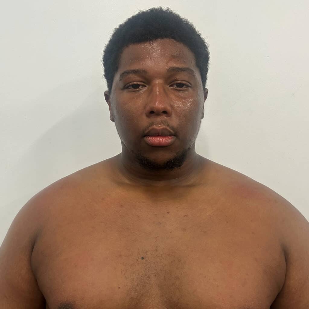 Sumo wrestler with sweat and tired expression.