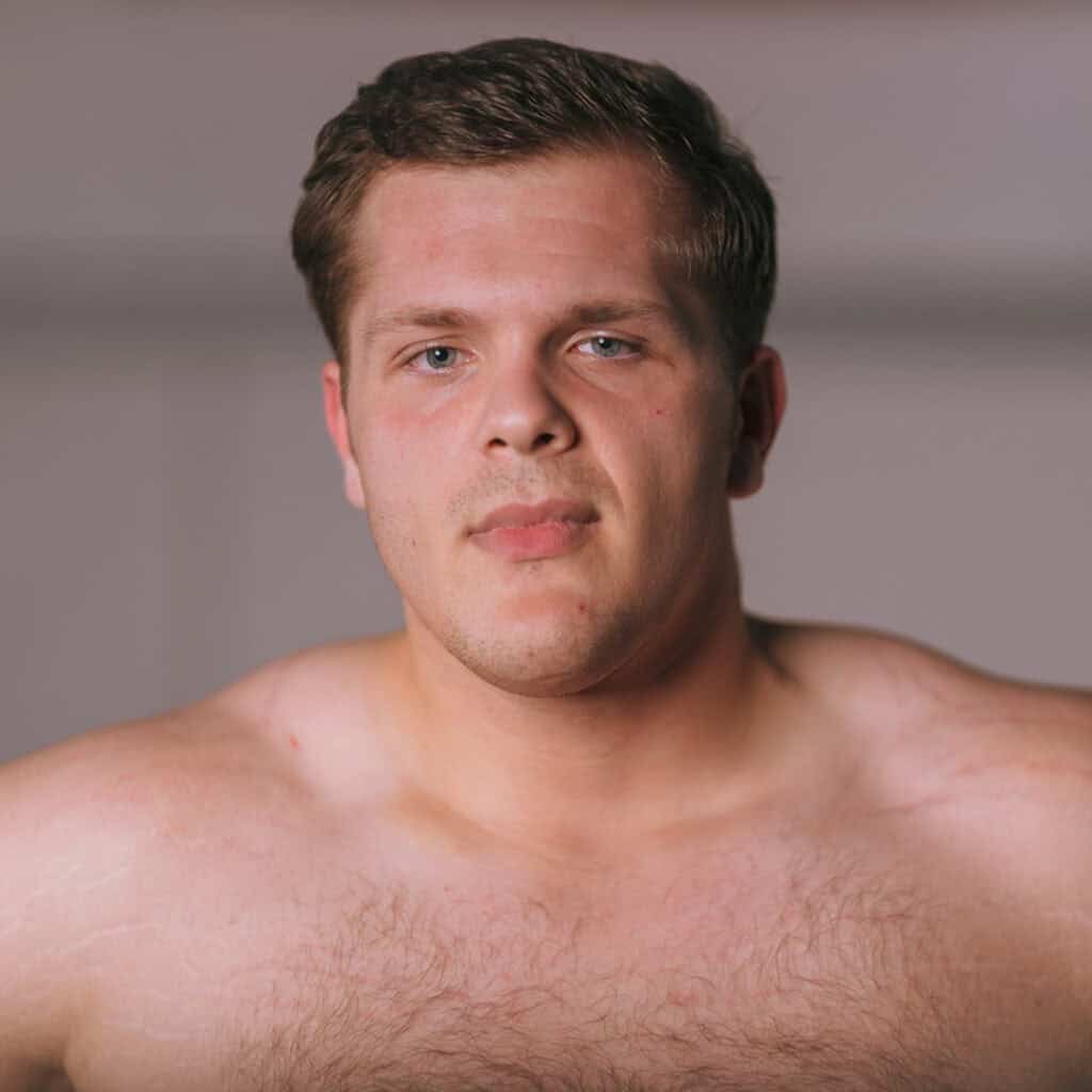 Close-up of a young man with short brown hair and blue eyes.