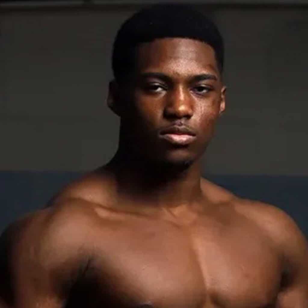 Portrait of a young man with dark skin and short black hair.